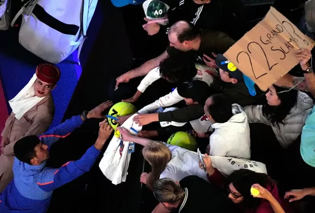 Djo Novak Djokovic firma autógrafos antes de retirarse de la pista.