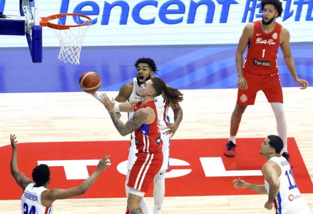 Isaiah Piñeiro ataca el canasto en medio de tres rivales.